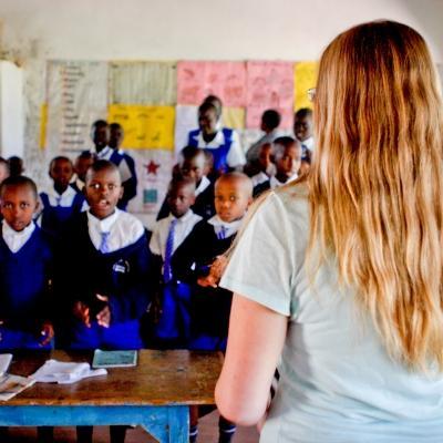 A Teaching volunteer in Kenya addresses her students before their class Students stand and listen to the Projects Abroad volunteer teaching them in Kenya